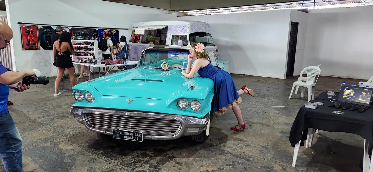 Automóvel clássico azul com modelo em estilo pin-up